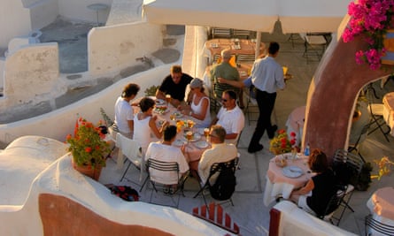 Diners in a picturesque restaurant with ocean view, in Oia.