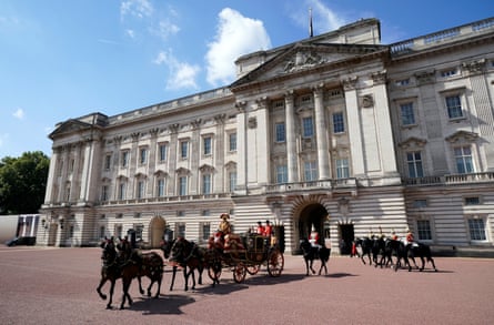 Horses parade outside a palace in bright sunshine
