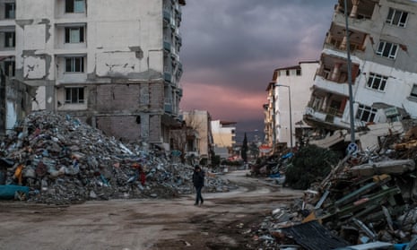 A man walks among buildings destroyed by an earthquake in southern Turkey in February.