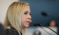 blond woman speaks in front of microphone
