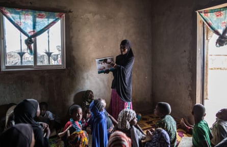 Children in Guinea learn about malaria prevention, a programme set up by charities and NGOs in collaboration with USAID.