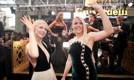 Busy Philipps and Michelle Williams turning towards the camera and waving