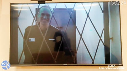 Screenshot of Alexei Navalny smiling behind bars