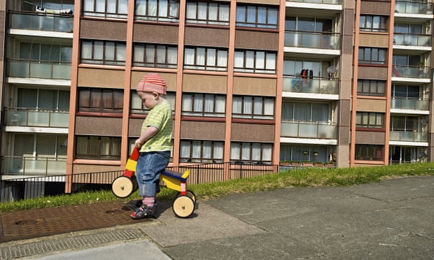 Small boy playing in front of Whitehawk housing estate, Brighton
