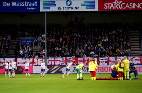 The worried England players look on as Alex Greenwood is placed onto the stretcher.