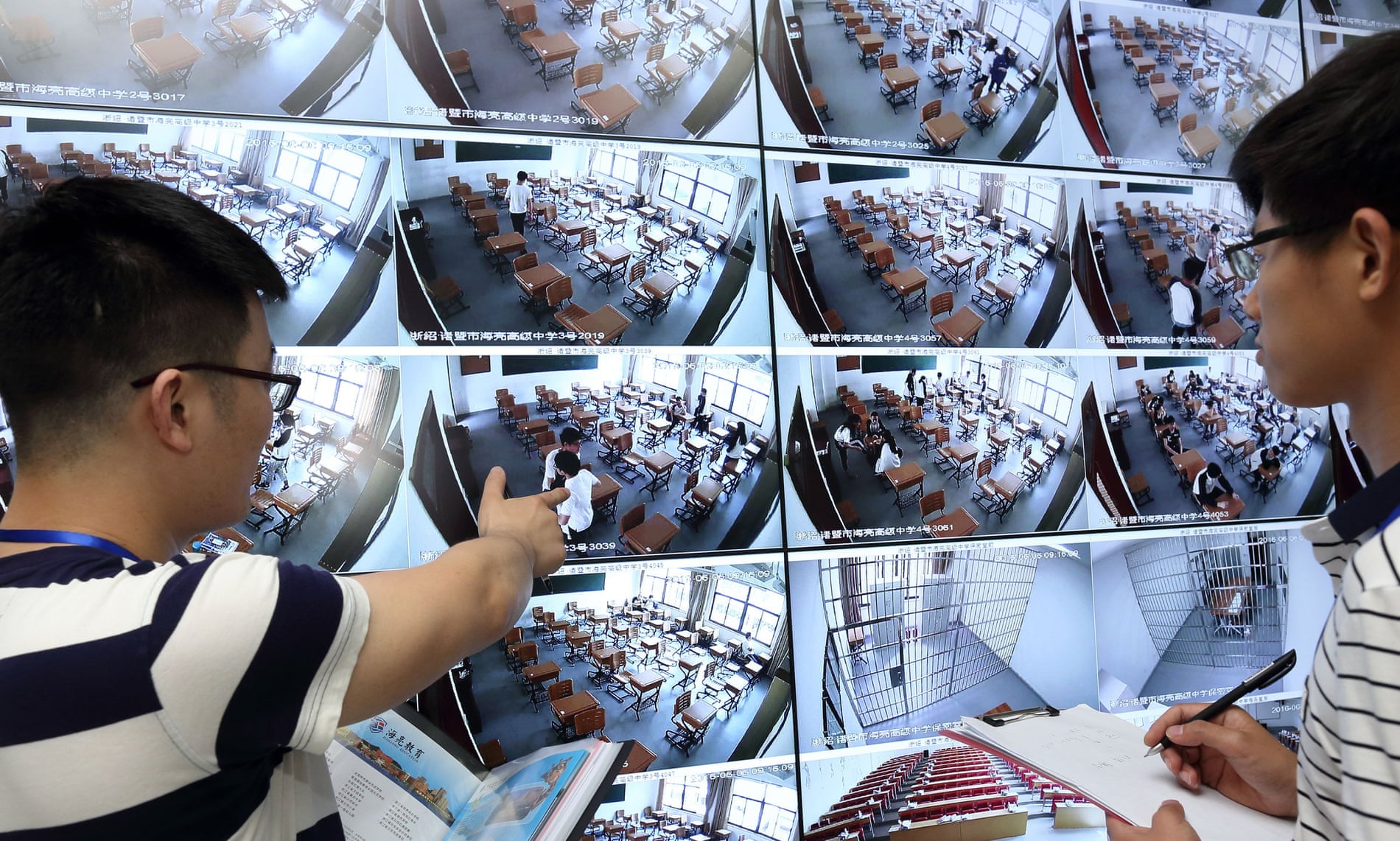 Invigilators use CCTV to inspect a classroom before the start of an exam at a school in Zhuji city, east China’s Zhejiang province.