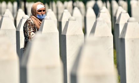 A Bosnian Muslim woman walks between tombstones at the Potocari memorial cemetery, where many of the victims of the 1995 massacre are buried.