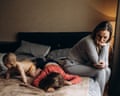 Playful chaos as children jump from sofa to sofa, surrounded by toys and balloons in a messy living room. Meanwhile, their tired mother reclines on the couch