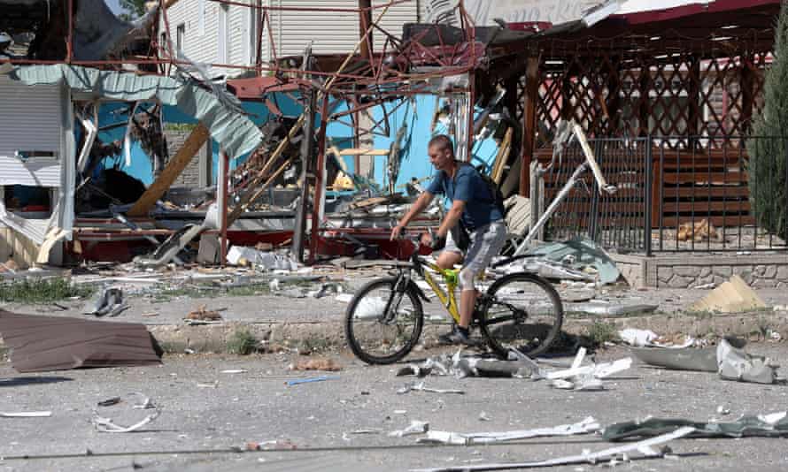 A man rides a bicycle among debris in Lysychansk on June 21, 2022, as Ukraine says Russian shelling has caused “catastrophic destruction” in the eastern industrial city, which lies just across a river from Severodonetsk where Russian and Ukrainian troops have been locked in battle for weeks.