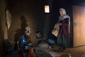 A young woman with her small daughter in a dark kitchen
