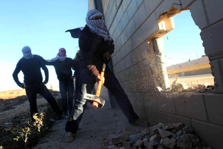 Palestinian activists opening a hole in a West Bank barrier earlier in November.