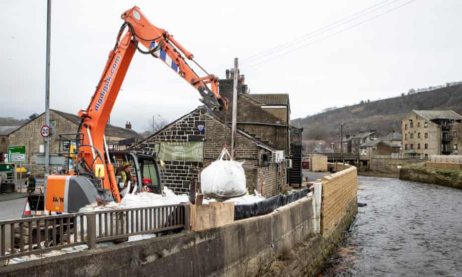 Workers construct flood defences in Mytholmroyd, West Yorkshire