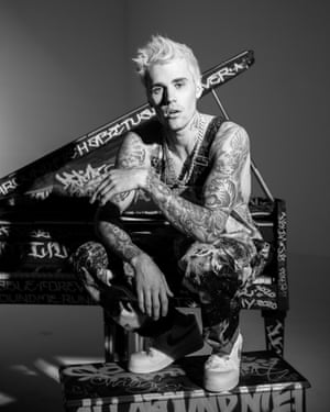 ‘Stream my record!’ …Justin Bieber sitting on a piano bench covered in graffiti