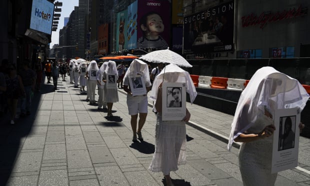 Protesters against gun violence dressed in white march in Times Square in response to recent mass shootings in El Paso, Texas and Dayton, Ohio, on Sunday in New York City. 