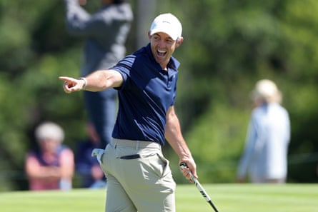 Rory McIlroy points and smiles on the course