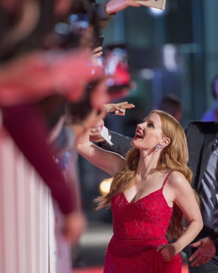 Jessica Chastain signs autographs on the red carpet.