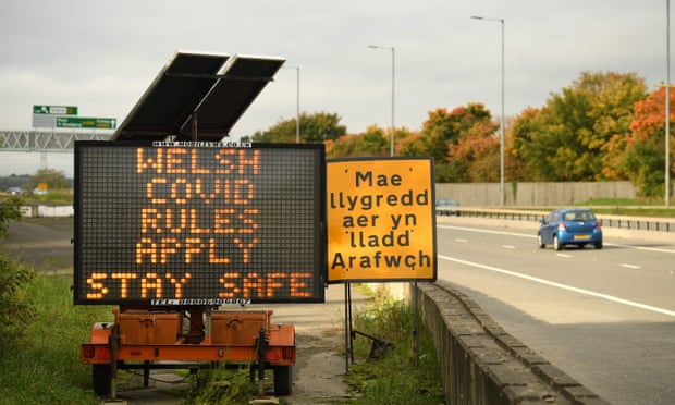 Traffic passes a ‘local Covid-19 rules apply’ sign displayed along the A494 near Queensferry in Flintshire.