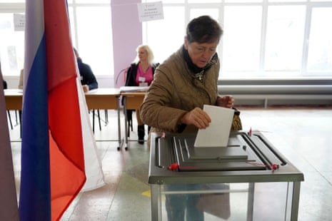 A woman casts her ballot in occupied Mariupol. The referendum has been dismissed as a “propaganda show” by Ukrainian authorities.