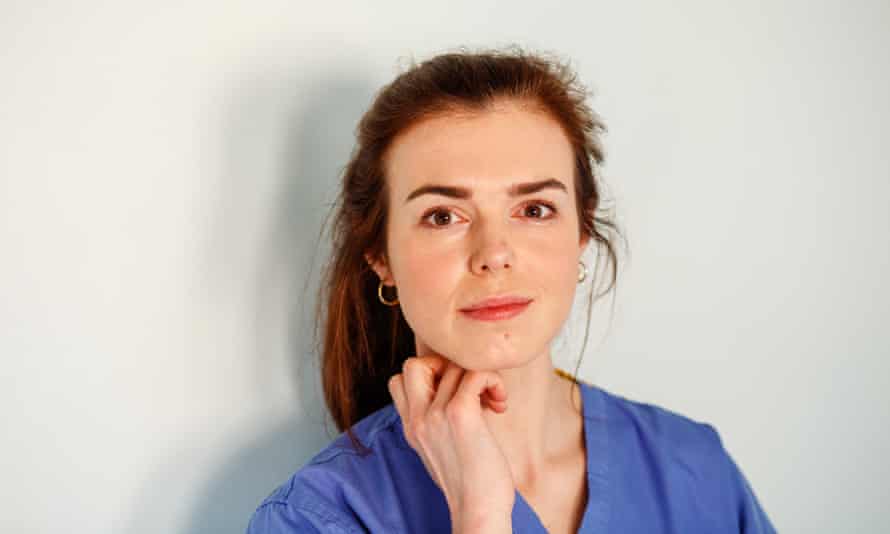 Kate Womersley head and shoulders, hand under chin, looking thoughtful