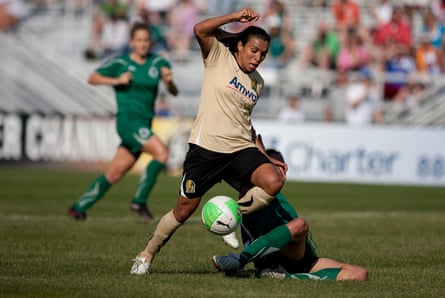 Marta dari FC Gold Pride berpacu melewati pemain St Louis Athletica yang terjatuh dalam upaya mencetak gol di babak kedua selama pertandingan pembuka musim 2010 di Anheuser-Busch Soccer Park di Fenton, Missouri.
