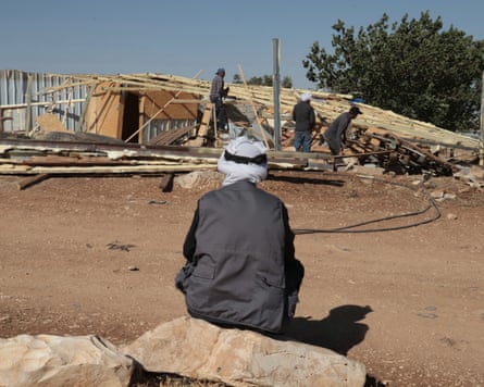 Palestinians dismantling a village as a result of nearby Israeli settlers presence.