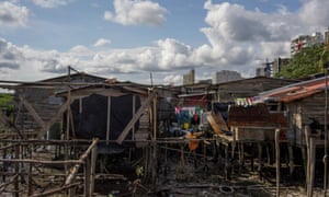 Stilt houses, known as palafitos, with modern buildings in downtown Buenaventura in the distance