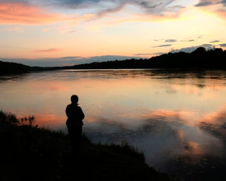 a person looks out across a river