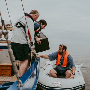 Loading the inflatable dinghy, in order to reach the sandbank with cooking utensils.