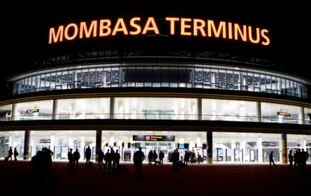 People silhouetted against the lit up Mombasa terminus at night
