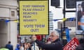 Protester with yellow placard reading: Tory Rwanda 'plan' finally reaches peak insanity. VOTE THEM OUT!