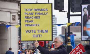 A man holding a sign reading 'Tory Rwanda 'plan' finally reaches peak insanity. Vote them out!' during a protest at Westminster