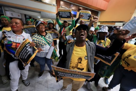 Supporters carry banners inside an airport