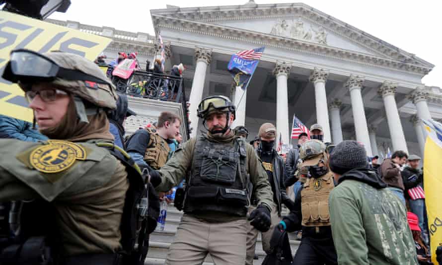 Members of the Oath Keepers seen marching down the front steps of the US Capitol.