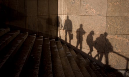 The shadows of anonymous people are seen on a wall