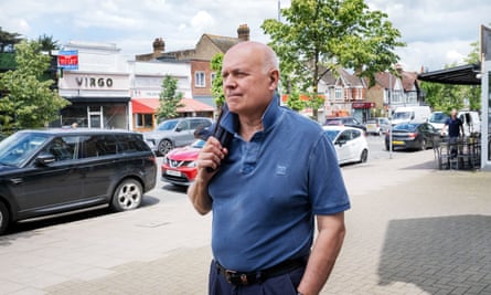 Iain Duncan Smith in a polo shirt walking along a street