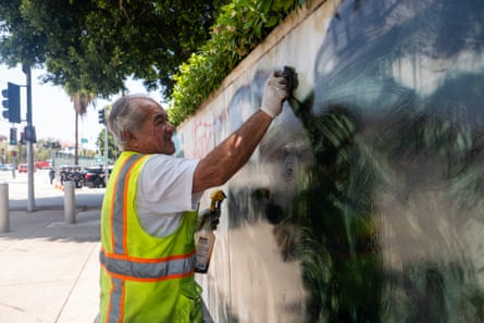 Person cleans graffiti off wall