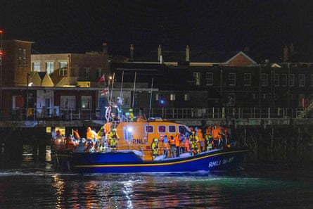 An RNLI boat at night with people in hi-vis on board