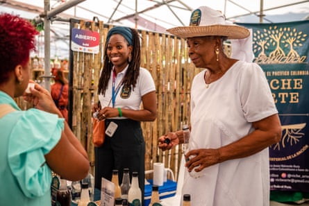 Vichera Mirta Valverde and her granddaughter offer Viche to visitors at the Petronio Alvarez festival.