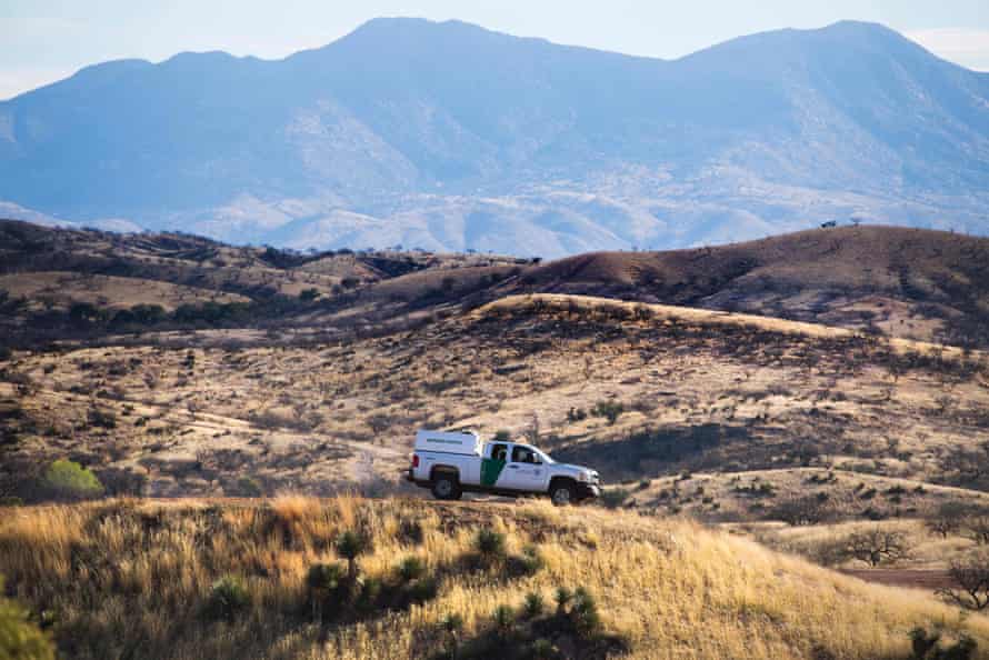 A US Border Patrol agent parks on a hill top near the border fence in Nogales, Arizona