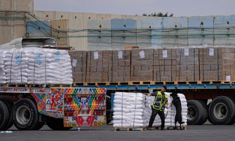 Trucks carrying humanitarian aid for the Gaza Strip pass through the inspection area at the Kerem Shalom Crossing in southern Israel, 14 March 2024.