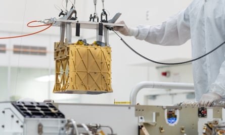 Technicians at Nasa’s jet propulsion laboratory lower the Moxie instrument into the belly of the Perseverance rover.