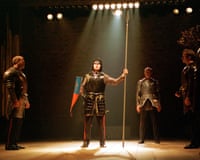 In Edward III, a knight raises a spear under a spotlight, watched by three armoured men