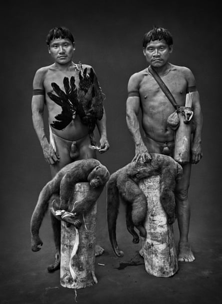 Hunters with a bird, a red-throated pipingguan, and two brown woolly monkeys brought down by poisoned arrows shot from blowguns.