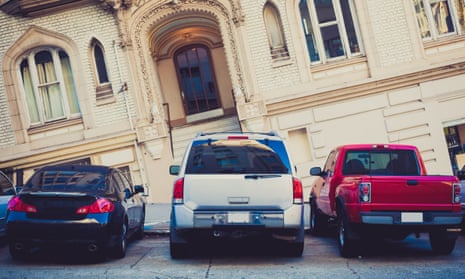 An SUV parked alongside other cars outside a sloped house in San Francisco.