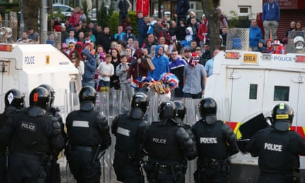 Police line up in front of loyalist protesters on the Crumlin Road in Belfast.