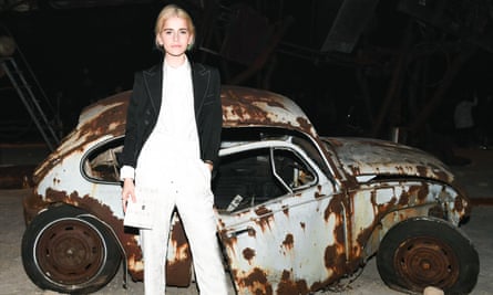 female model in front of wrecked old car