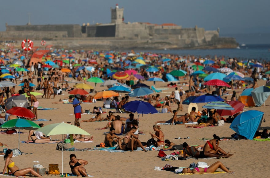People enjoy the sunny weather at Carcavelos beach, near Lisbon, amid the coronavirus pandemic.