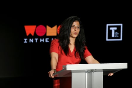 A young Arab woman speaks at a lectern at a conference