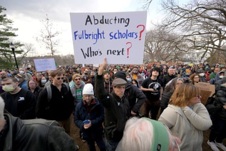 a person holds a sign that reads ‘abducting Fulbright scholars? who’s next?