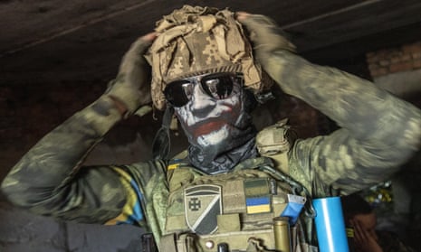 A Ukrainian sniper puts on a balaclava in a cellar in Siversk on Friday.